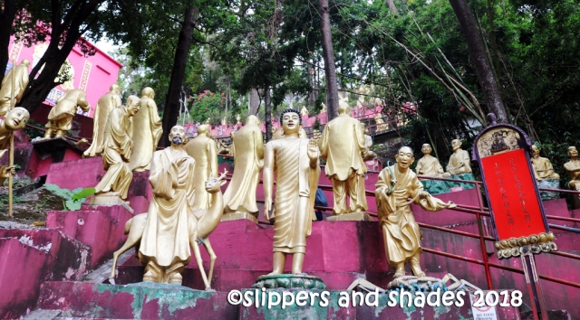 the Golden Buddhas are lined on both sides in different poses